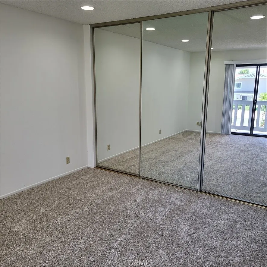 Primary bedroom with mirrored wardrobe doors
