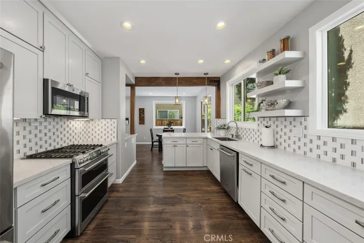 Beautifully remodeled kitchen featuring quartz countertops, stainless steel appliances, and abundant cabinetry.