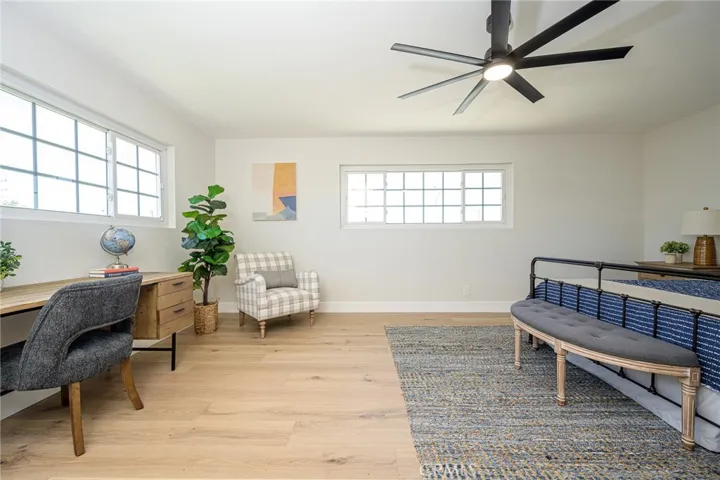 Upstairs primary bedroom with luxury flooring and ceiling fan