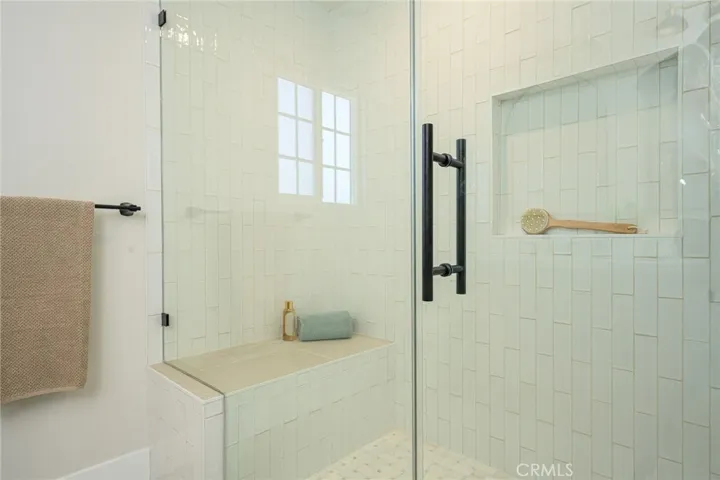 Upstairs primary bathroom with walk in shower with custom tile work