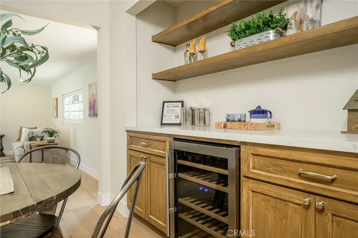 Built in wine fridge with additional cabinets space and shelving