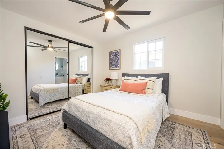 Downstairs primary bedroom with luxury flooring and ceiling fan