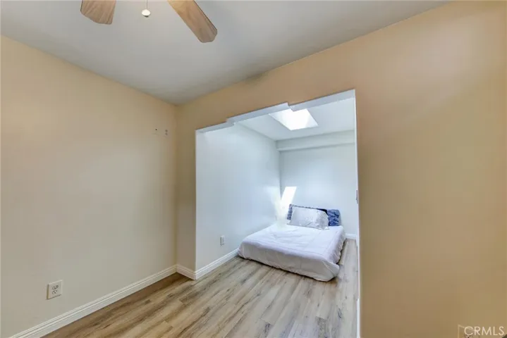 Another view of third bedroom with ceiling fan and skylight