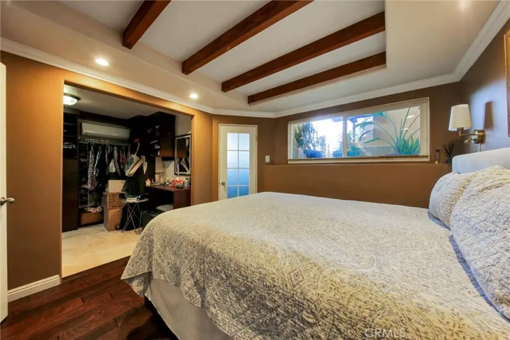 Primary bedroom and custom walk-in closet view from French doors to living room