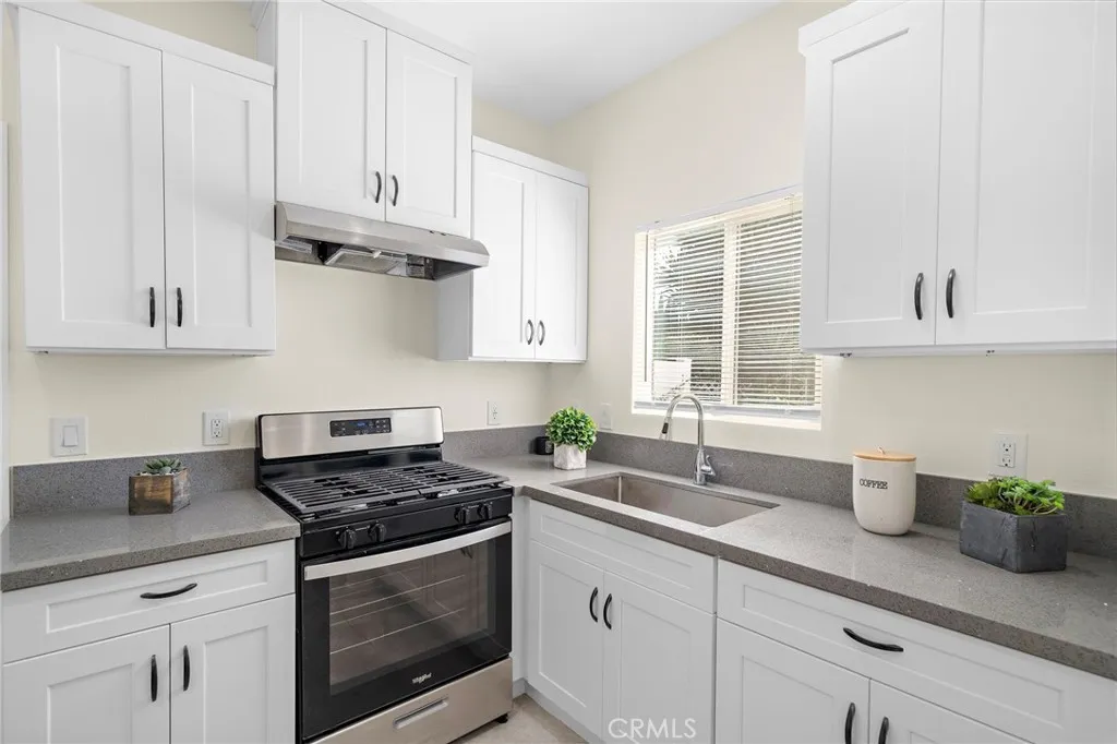 ADU Kitchen with quartz countertops, gas stove, and white shaker cabinetry