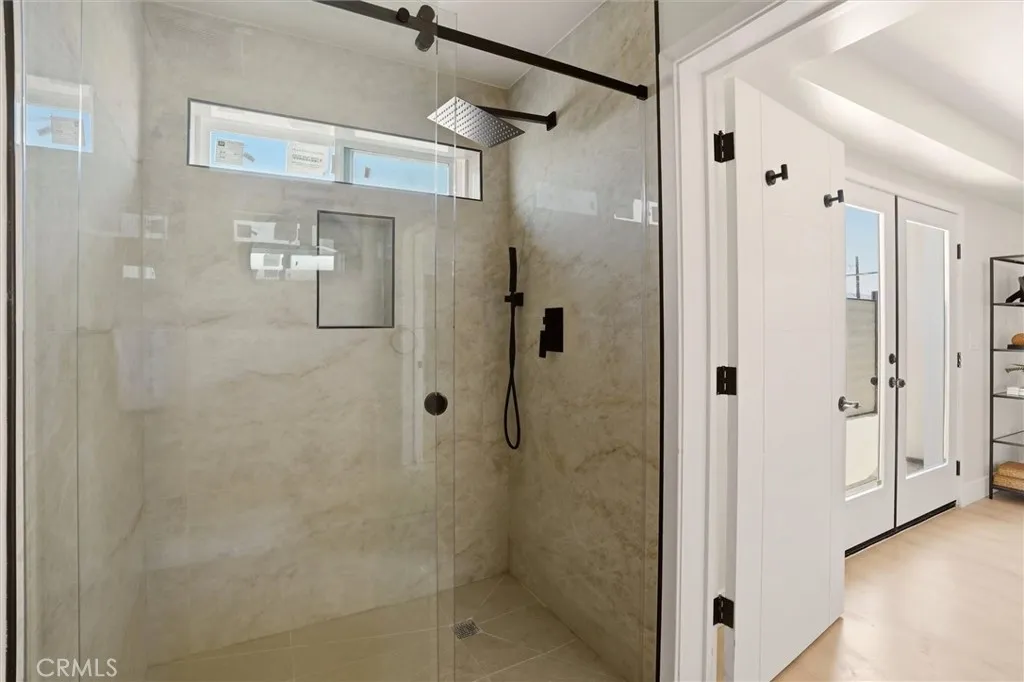 Modern tiled shower in the main level bathroom has a waterfall shower head