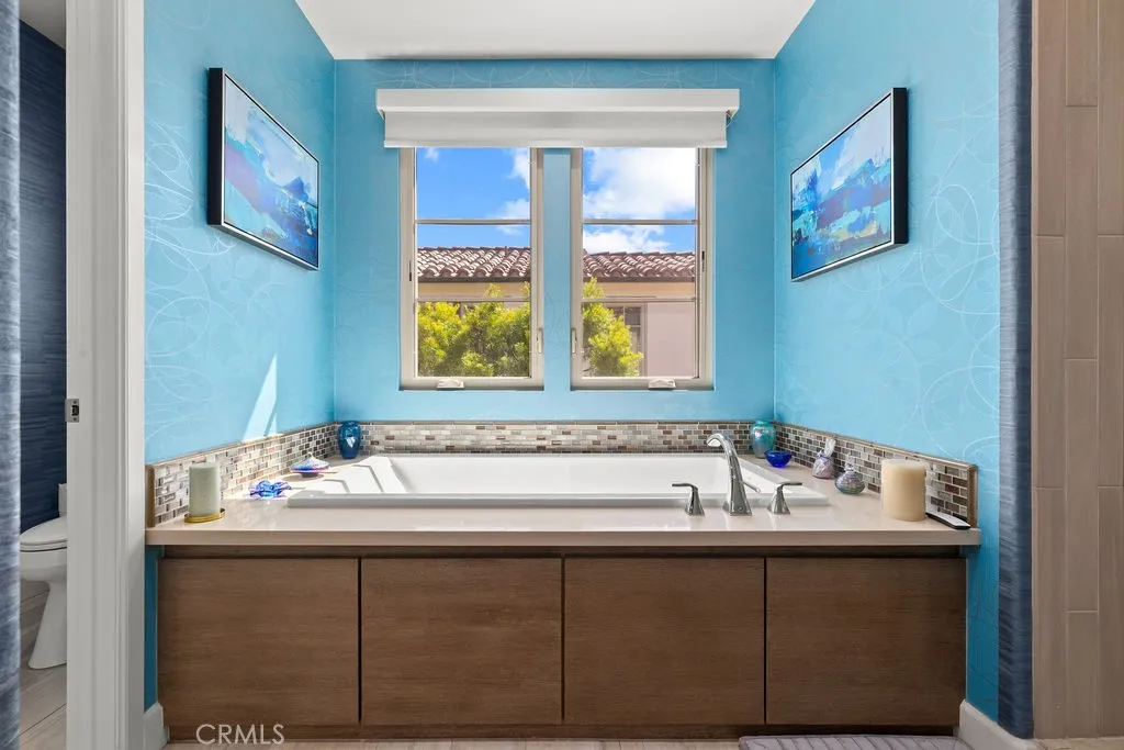 Soaking tub with custom window coverings overhead for privacy