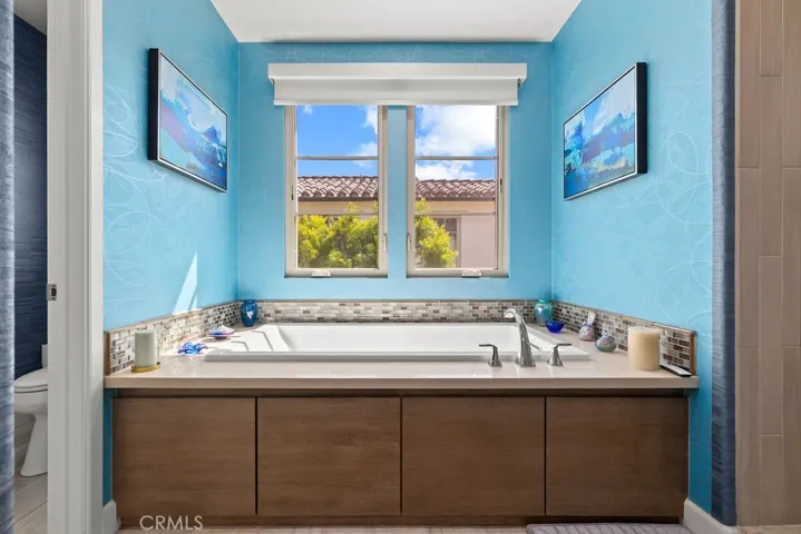 Soaking tub with custom window coverings overhead for privacy