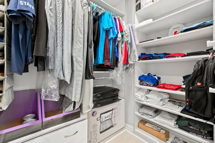 Walk in closet in primary bathroom hallway