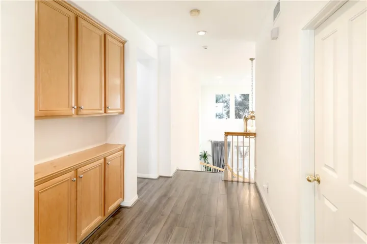 Second level hallway with built-in cabinets