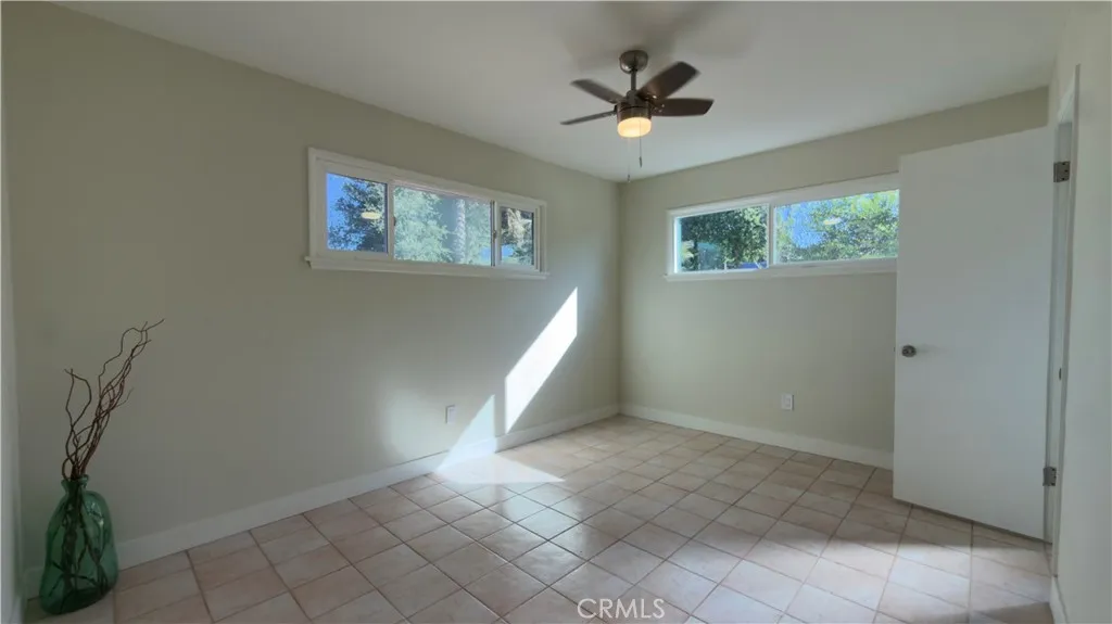 PRIMARY ROOM WITH NEW PAINT AND CEILING FAN.