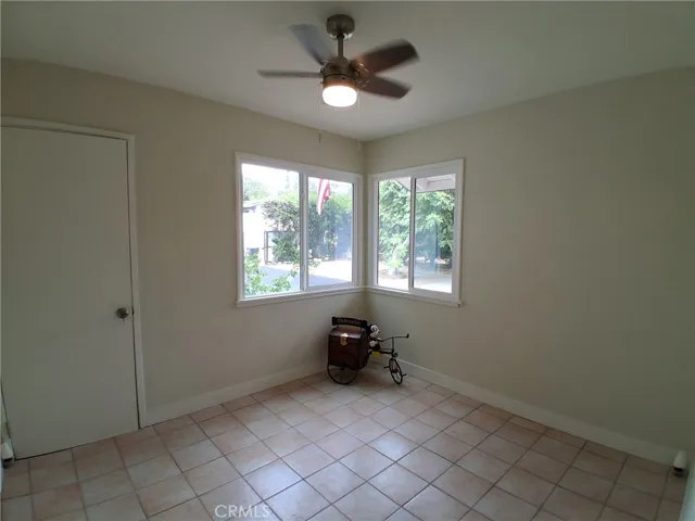 Third Bedroom, bright and comfortable, featuring a new windows and ceiling fan for added comfort and natural light. leads to garage.
