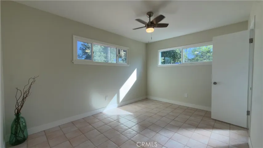PRIMARY ROOM WITH NEW PAINT AND CEILING FAN.