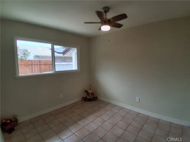 First bedroom, bright and comfortable, featuring a new window and ceiling fan for added comfort and natural light.