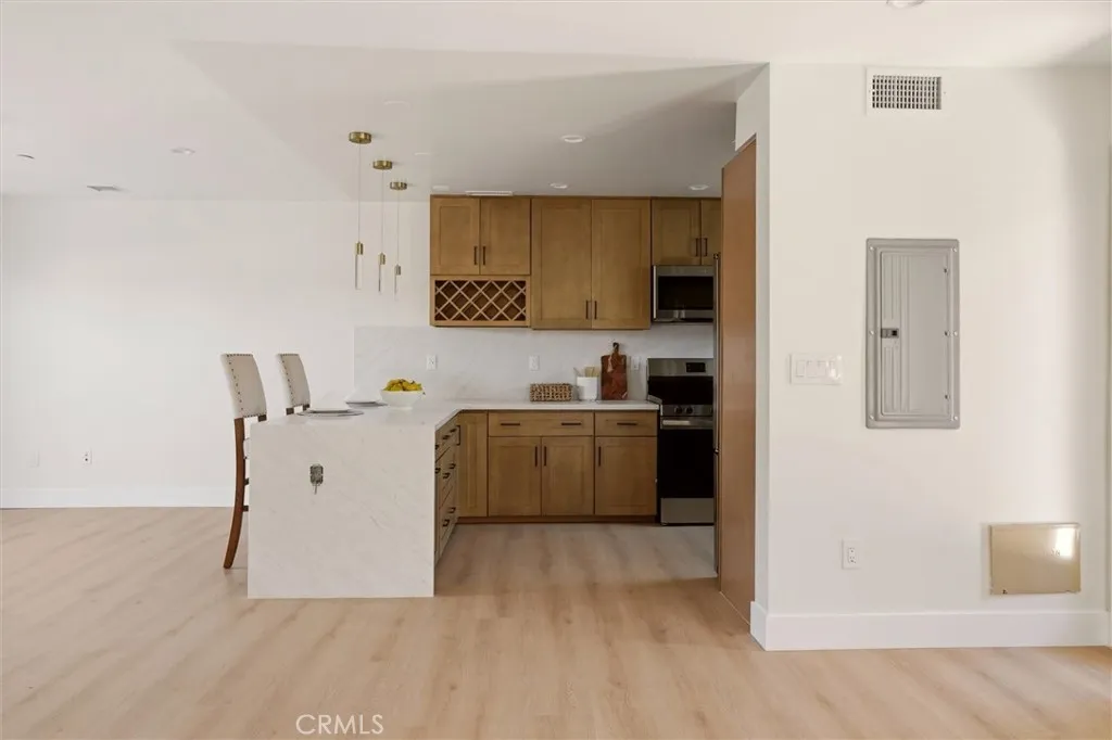 Unstaged living space and kitchen area from unit B, showing waterfall counter top