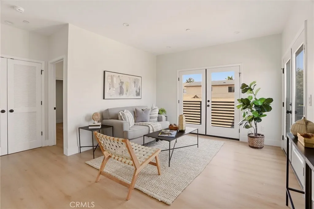 Staged second level living area with access to second level balcony, photo from Unit A (nearly identical unit)