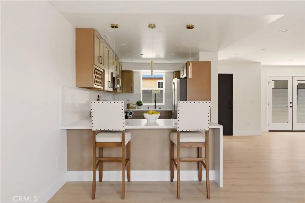 Unstaged living space and kitchen area from unit B, showing waterfall counter top