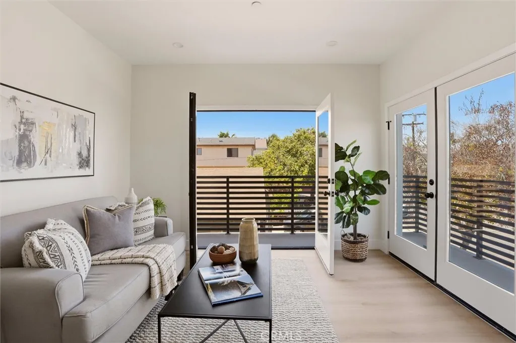 Staged second level living area with access to second level balcony, photo from Unit A (nearly identical unit)