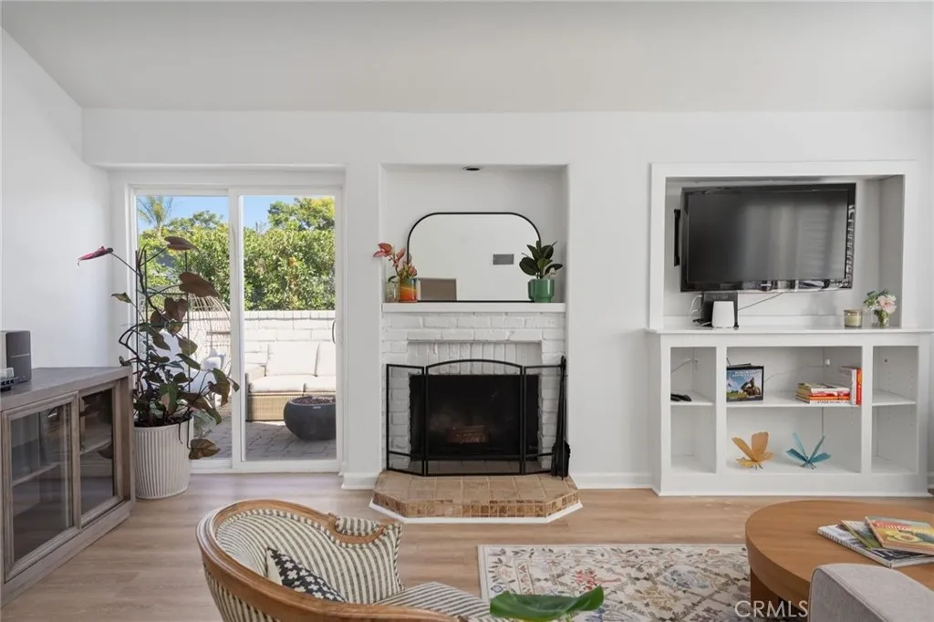 Living Room with built in & fireplace, access to patio