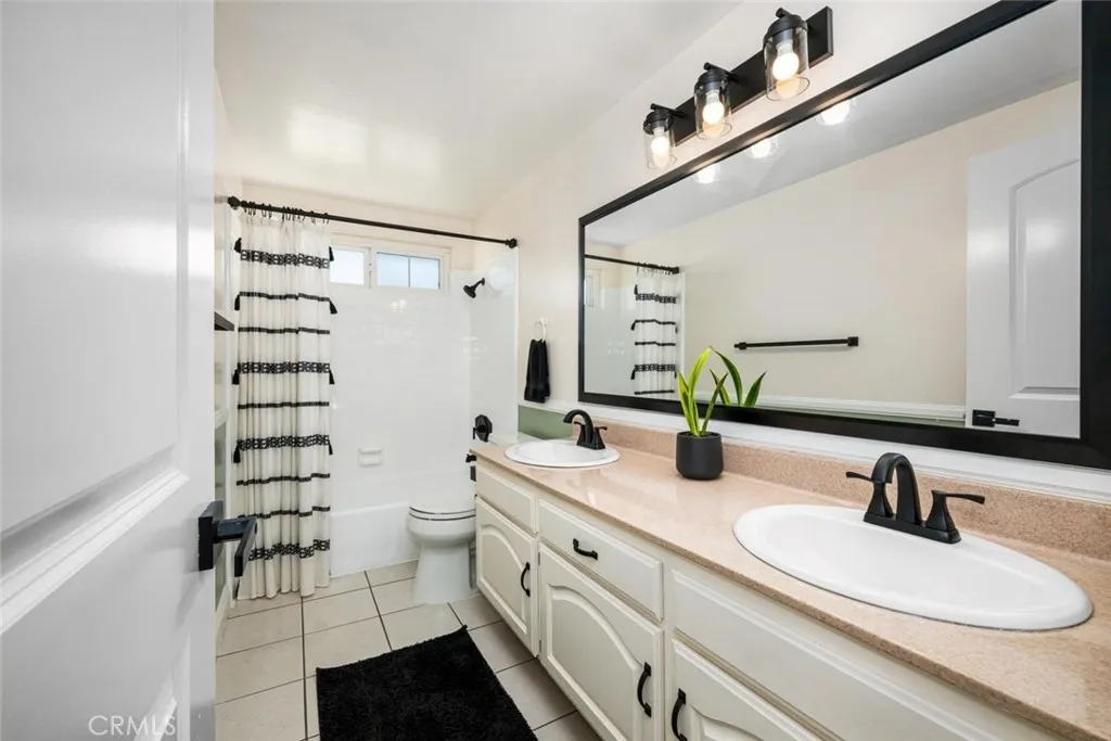 Hallway full bath with double sink vanity.