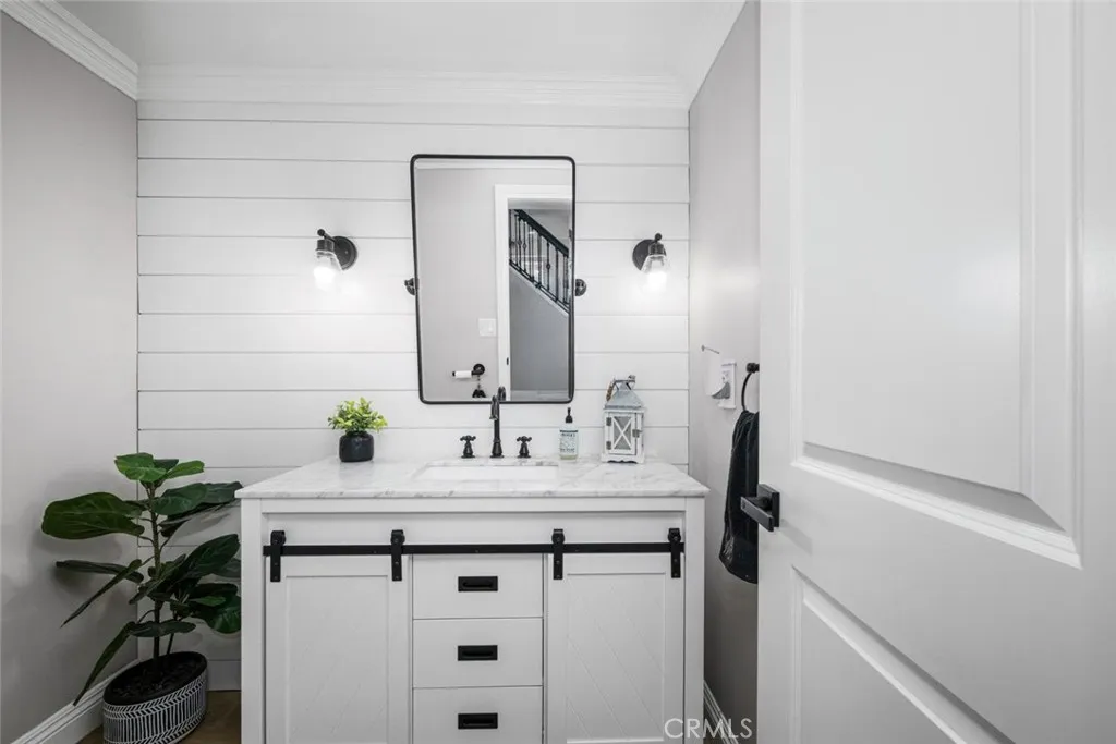 Showcasing shiplap paneling for texture, stylish quartz vanity, and fixtures.