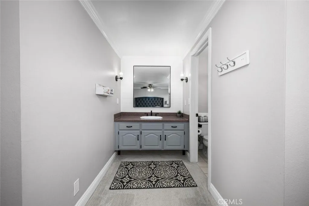 Vanity area with Corian countertops, upgraded with shiplap, mirror, and fixtures.
