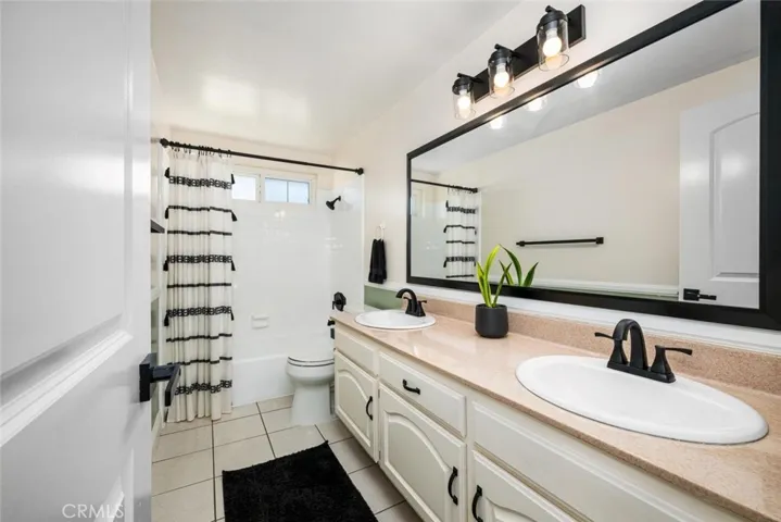 Hallway full bath with double sink vanity.