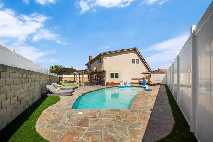 Stonework and new artificial grass outline the pool for a polished look.