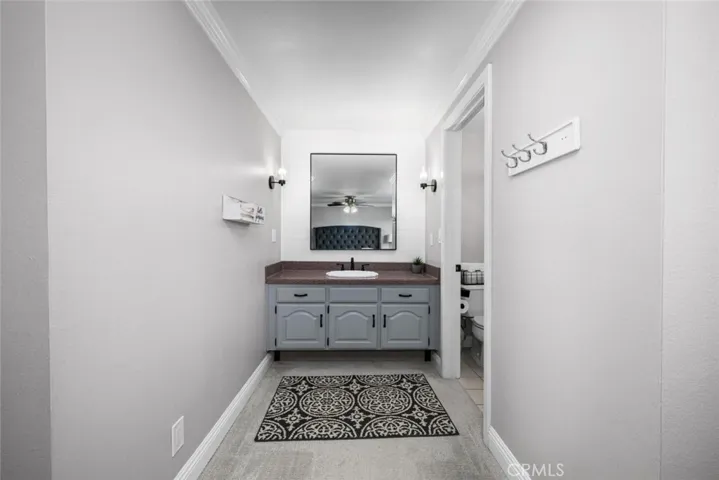 Vanity area with Corian countertops, upgraded with shiplap, mirror, and fixtures.