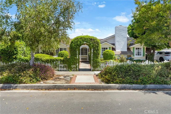 Storybook curb appeal with mature landscape.