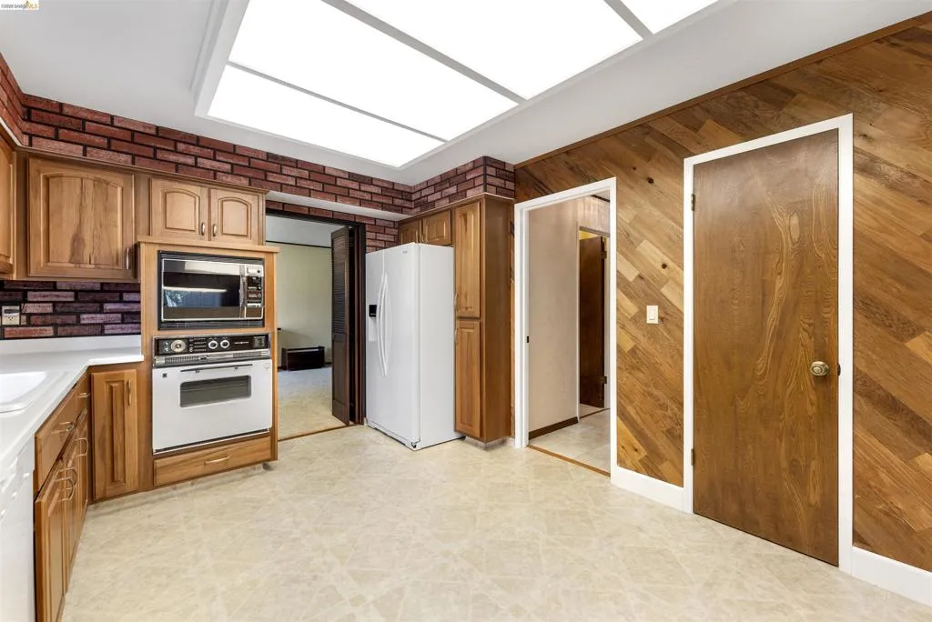 Kitchen featuring light wood cabinetry, white countertops, built-in microwave and oven, a white refrigerator, and recessed ceiling lighting