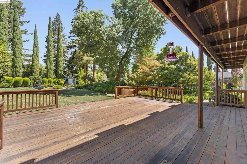 Expansive wood-finish deck with wood railings, providing an open outdoor living space