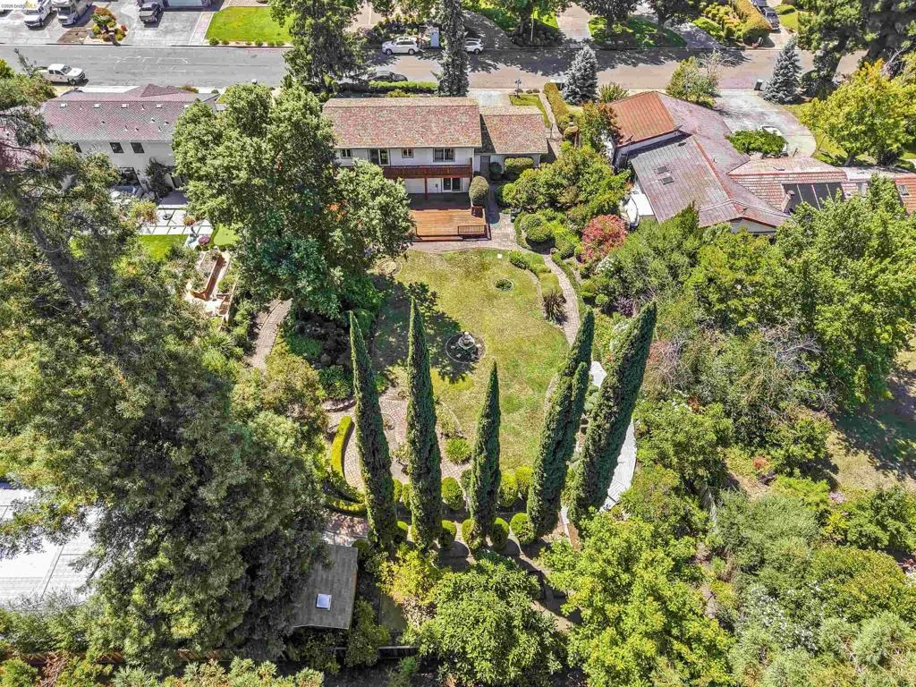 Expansive property featuring a multi-level residence with a red tile roof and rear deck