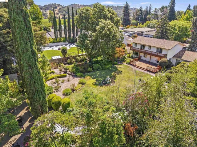 Expansive property featuring a two-story residence with a ground-level deck and upper-level balcony