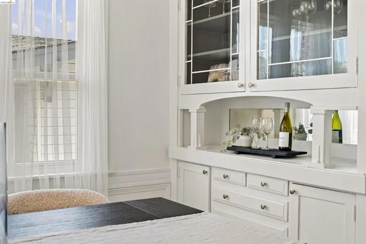 Built-in cabinetry featuring glass-front upper doors, lower storage with drawer and cabinet space, and a central counter area