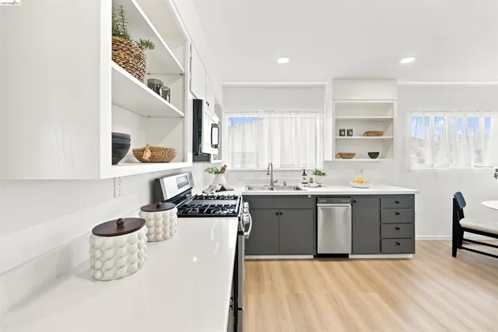 Contemporary kitchen featuring white shaker upper cabinetry and open shelving