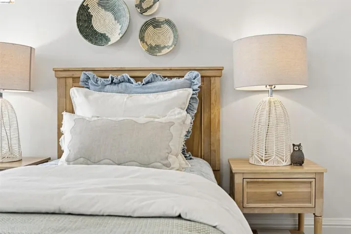 Wood-finish headboard and matching nightstands flank the bed