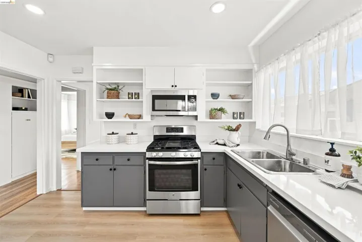 Kitchen with two-tone cabinetry, white countertops, and stainless steel appliances