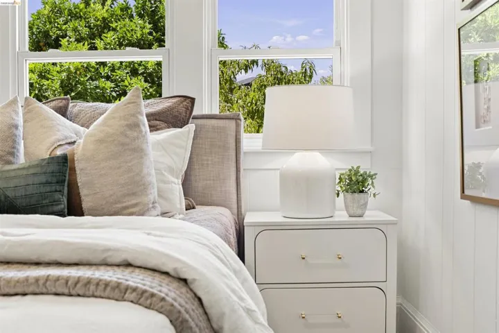 White paneled walls and trim frame a window with outdoor greenery