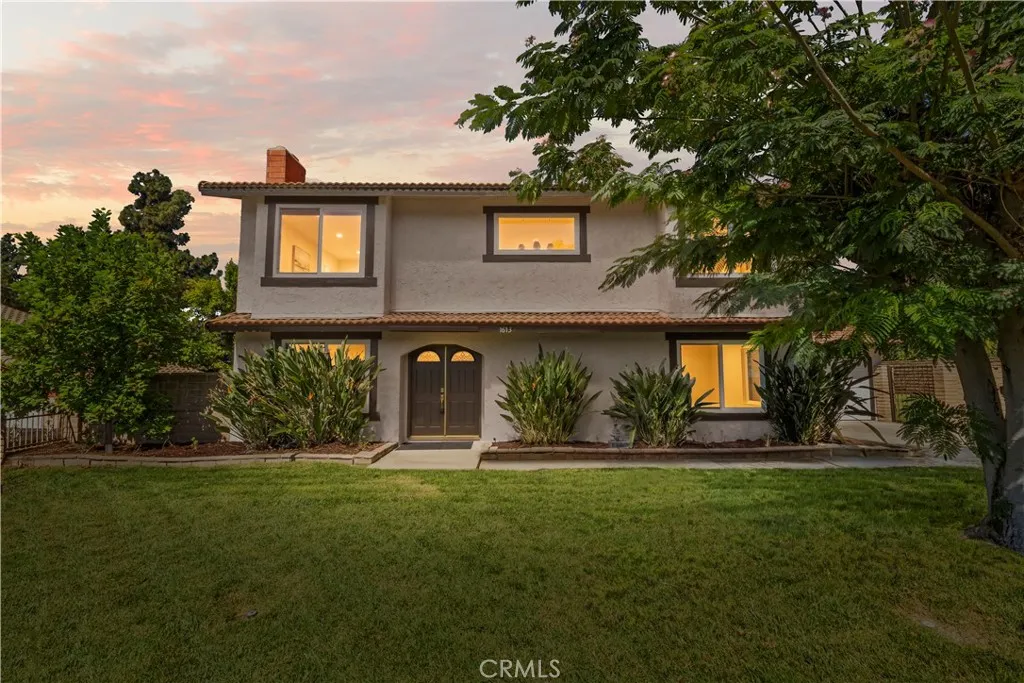 Welcome home — pristine curb appeal with a manicured lawn and mature shade tree