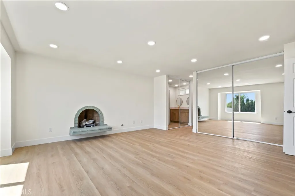 The mirrored closet wall amplifies natural light throughout the room