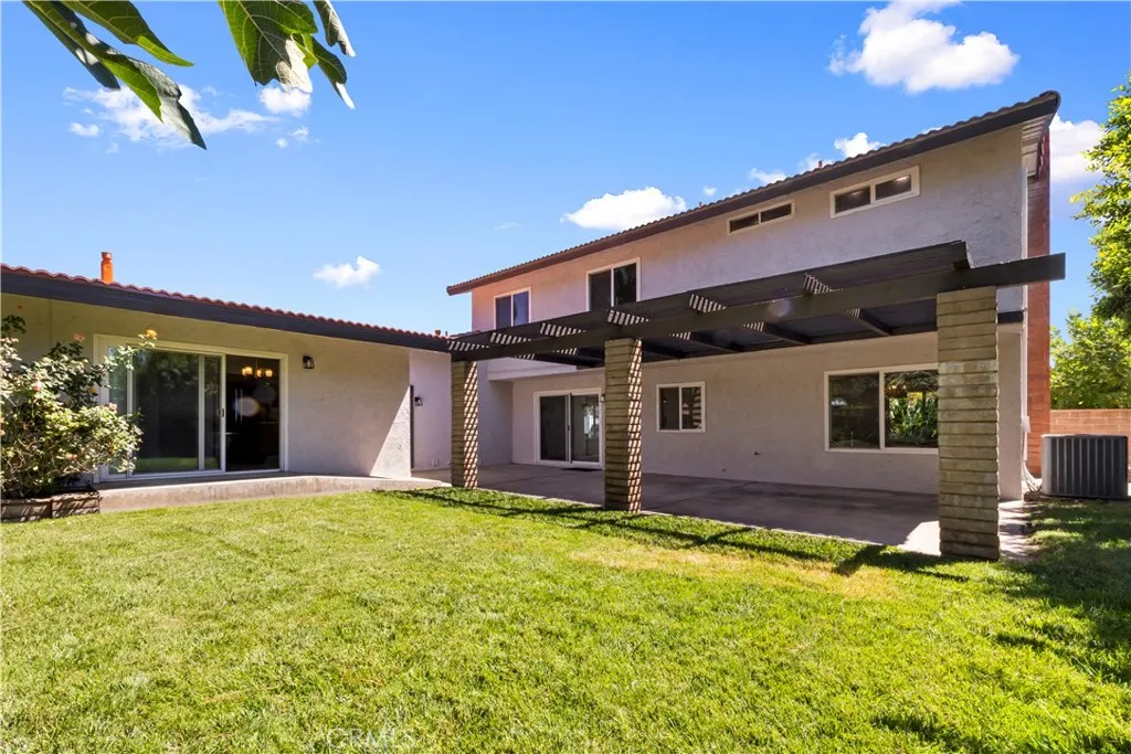 Spacious backyard with colorful blooms and mature fig tree