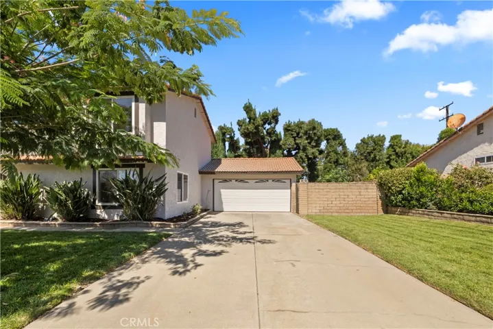 Wide driveway with ample parking, attached garage and potential RV parking.