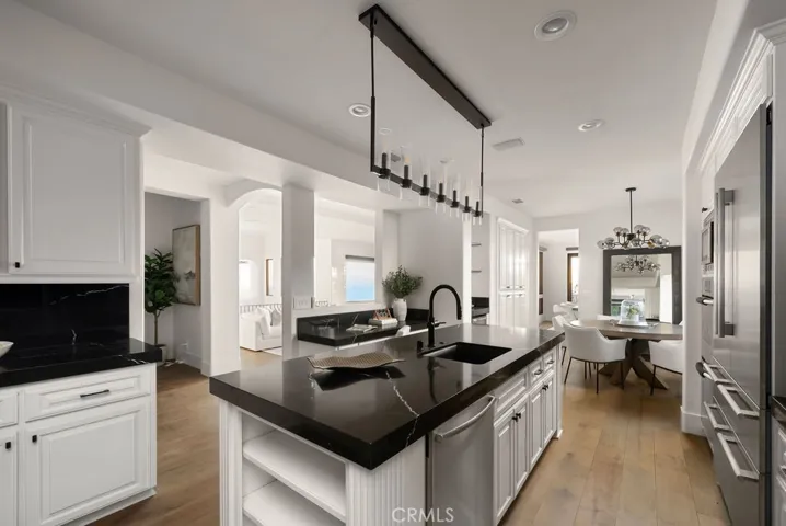 Gourmet kitchen featuring a casual dining area, expansive center island, quartz countertops, and an abundance of custom cabinetry.
