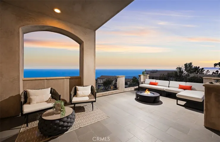 One of many expansive viewing terraces, offering inviting lounge seating, a fire feature, and breathtaking ocean and sunset views—perfectly capturing Laguna Beach’s ultimate indoor-outdoor lifestyle.