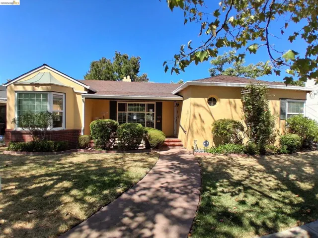 Stucco exterior with a bay window and brick detailing