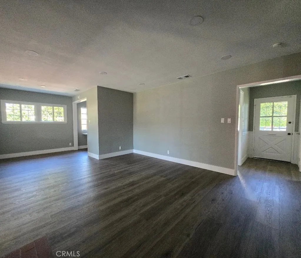Open floor plan connects the front entrance, living room, and dining area into one bright, flowing space without boring walls