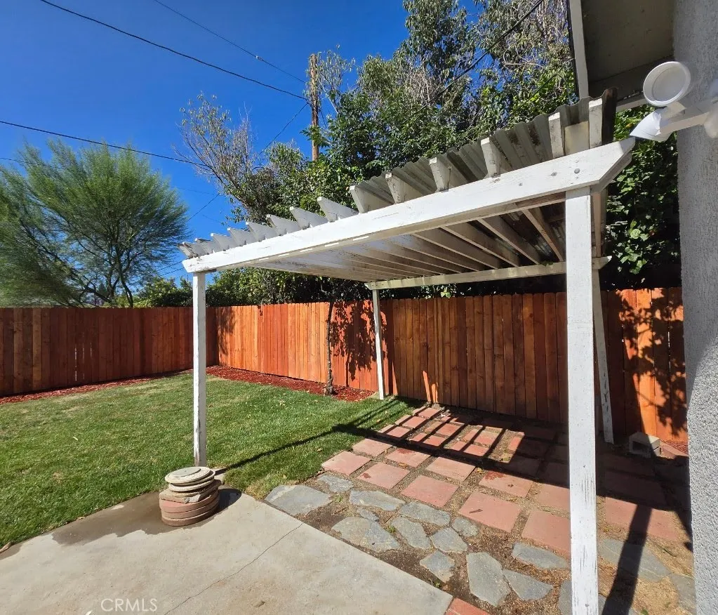 Charming pergola offers a welcoming setting for outdoor relaxation and entertaining Charming pergola offers a welcoming setting for outdoor relaxation and entertaining