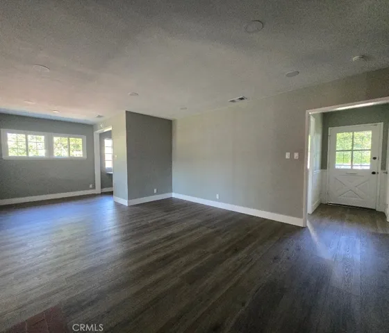 Open floor plan connects the front entrance, living room, and dining area into one bright, flowing space without boring walls