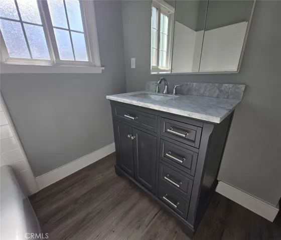 Stylish guest bathroom featuring an updated vanity with an elegant stone countertop and contemporary finishes